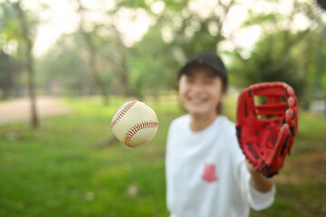 School girl in baseball glove catching a ball. Sports and youth lifestyle concept
