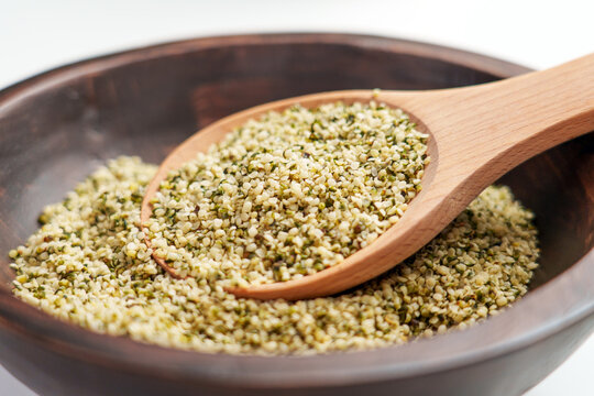 Wooden spoon with legal alimentary hemp seeds in rustic bowl