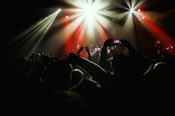 The audience is immersed in the experience, illuminated by radiant beams of stage light on live...