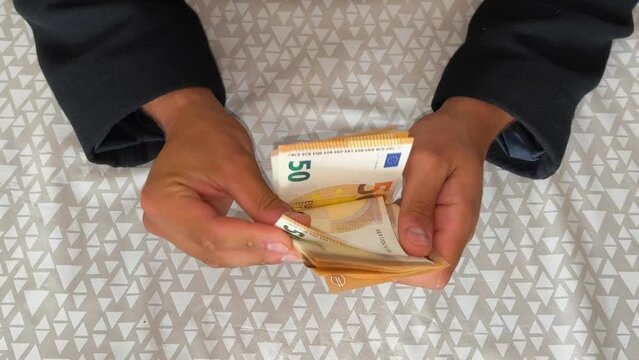 M&atilde;os masculinas contando notas de euro sentado na sala &agrave; mesa. Banca e finan&ccedil;as. Estilo de vida empresarial. Conceito de trabalho financeiro