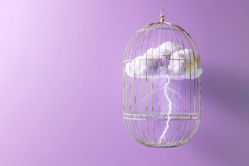 Thundercloud with lightning in birdcage on purple background. The concept of creative freedom. .