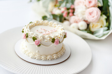 Festive bento cake and bouquet on a light background