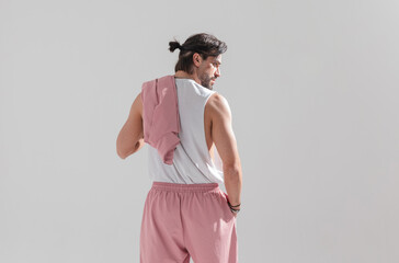 behind view of muscular fit guy with hair tail holding hand in pocket