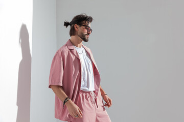 side view of cool fashion man in pink clothes looking to side