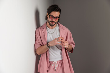handsome young man in pink casual clothes with sunglasses