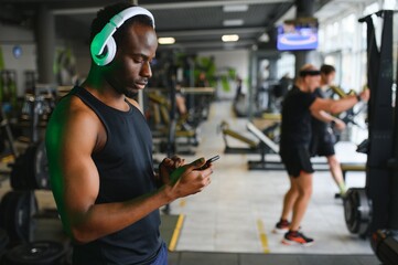 African American man listening motivational music over headphones improving quality of workout