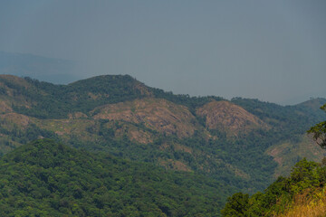 The mountains are covered in trees and the sky is cloudy