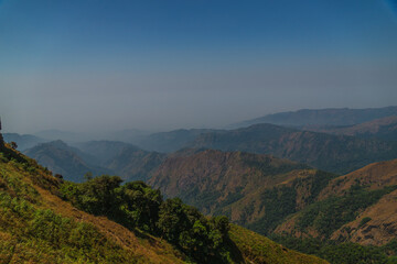 The mountains are covered in trees and the sky is clear