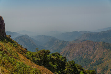 The mountains are covered in trees and the sky is cloudy