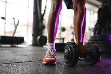 Close-up of a man takes a dumbbell in the gym