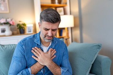 Man presses hand to chest has heart attack suffers from unbearable pain, Mature man with pain on...