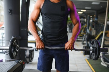 Athletic black guy making weightlifting or powerlifting at modern gym