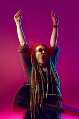 Talented guitarist with dreadlocks, wearing sunglasses and a beanie hat, captivating audience with...
