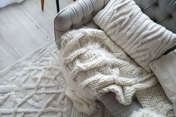 Flat lay of stylish couch with knitted blanket and pillow in modern interior