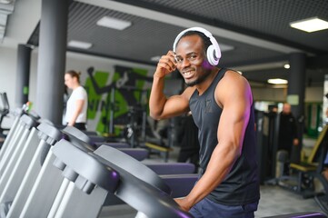 African American man listening motivational music over headphones improving quality of workout