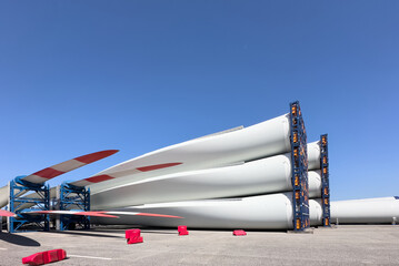 blades of wind turbines stack in a harbor and ready for shipping and assembling
