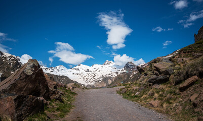 Trail for trekking. Mountain rocky peaks covered with snow and glaciers on a bright sunny day. Amazing trekking in the mountains.