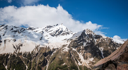 Mountain rocky peaks covered with snow and glaciers on a bright sunny day. Amazing trekking in the mountains.