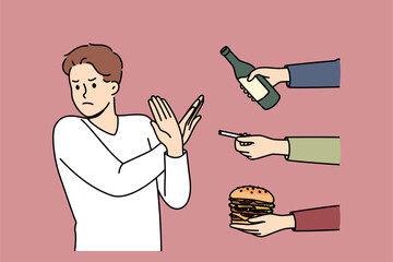 Man gives up bad habits, making forbidden gesture near hands with alcohol and cigarettes or fast food. Guy says stop bad habits to start healthy lifestyle and avoid loss of immunity