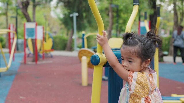 Cute little asian girl play on school kindergarten yard playground healthy summer activity for children. Child playing on outdoor playground