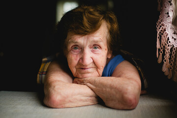 Portrait close-up of Elderly Woman at the Table - 779665522