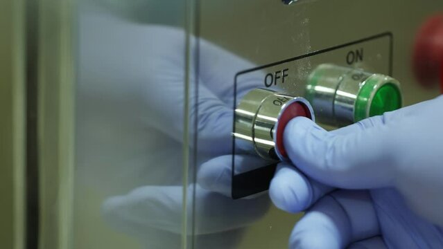 Man in protective gloves setting up scientific equipment.