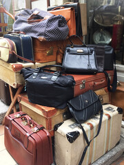Suitcases and other used bags are displayed on the street for sale. Theme is flea market. El Rastro. Madrid, Spain.