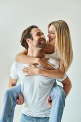 A blonde woman tenderly holds a man in her arms in a passionate display of romance and intimacy.