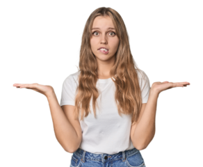 Studio portrait of a blonde Caucasian woman confused and doubtful shrugging shoulders to hold a copy space.