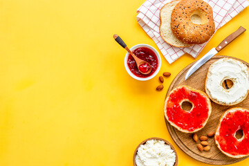 Baked bread bagels with with berry jam and cheese cream. Healthy breakfast background