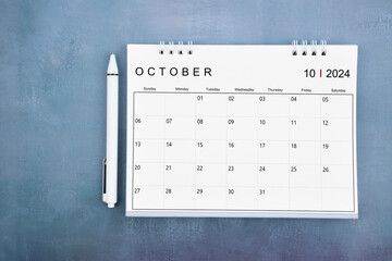 Directly above view of October 2024 desk calendar and pen