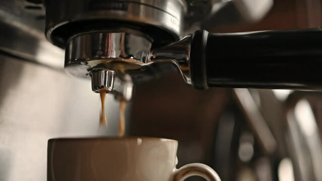 Coffee maker preparing fresh espresso in cup. Professional cappuccino machine and mug with italian aroma beverage