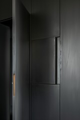 A gray cabinet door with an open window on the side, a minimalist modern interior design style, a slightly angled view of the inside wall