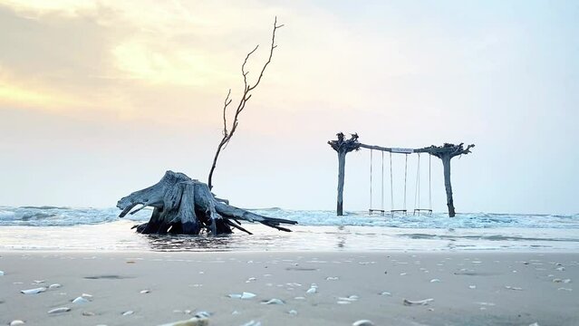 A relaxing beach scene with a swing gently swaying in the breeze. The ocean waves crash softly in the background, creating a serene and peaceful atmosphere. Perfect for travel, lifestyle, or wellness 