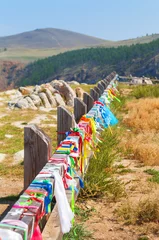 Rolgordijnen Coast of  Baikal Lake in summer. Northern tip of Olkhon Island. View of colorful tourist ribbons on fence of parking at Cape Sagan-Khushun. Natural background. Summer travel and outdoor recreation  © Katvic