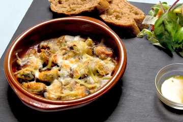 Tragetasche Zeeuwse hangcultuurmosselen, gegratineerd in de oven met kaas. Geserveerd met brood, salade en saus als voorgerecht © ArieStormFotografie