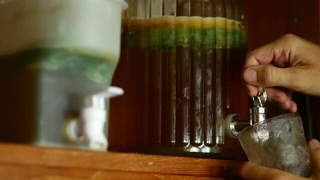 Pouring Kombucha from Large Dispenser Jar