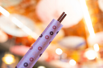 Close-up of a packet of Chinese or japanese chopsticks for eating oriental Asian food with a warm,...