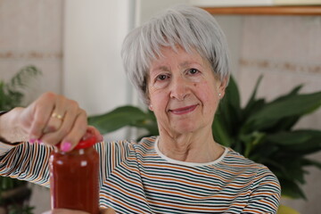 Senior woman trying to open a jar 