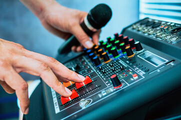 Close-up of sound engineer hands adjusting control sound mixer in recording, broadcasting...