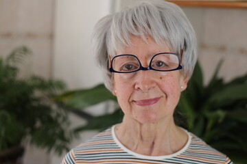 Senior woman wearing her eyeglasses upside down 