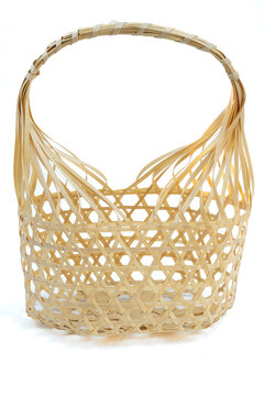 Chalom or round bamboo basket is a natural basketry using bamboo that is weaved together to form a basket for use in holding various things. Bamboo basket on a white cardboard background.