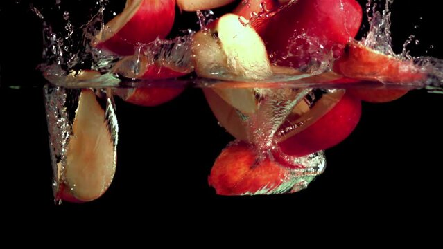 Super slow motion red apples fall on the water with splashes. Filmed on a high-speed camera at 1000 fps. High quality FullHD footage