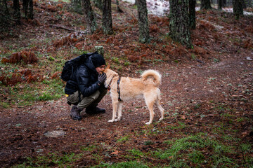 Snowy landscape, Peruvian man and his pet dog bond in forest tranquility.