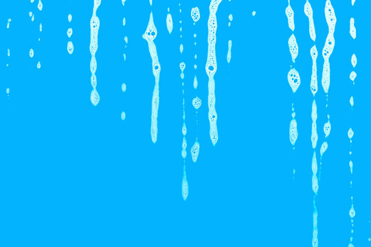 soap foam water drops on window glass, blue background