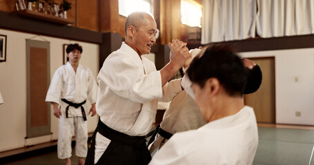 Aikido class, man and sensei for martial arts, learning and advice for combat at training, gym and dojo. Japanese people, master and sports with fight, workout and fitness for zen, conflict or club