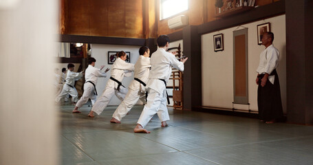 Aikido, black belt and fight class with sensei training or teaching athletes for self defence exercise. Dojo, students and people in a gym or studio for workout, practice and fitness routine in Japan - obrazy, fototapety, plakaty
