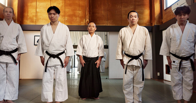 Japanese students, bow or learning aikido in dojo, training and modern martial arts for self defence or respect. Group, black belt class and sensei in instruction, honor and discipline in commitment