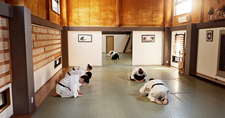 Aikido class, group and students of martial arts, bow and respect with calm at training, gym dojo. Japanese people, black belt and club for exercise, workout or fitness with fight, conflict or battle - Powered by Adobe