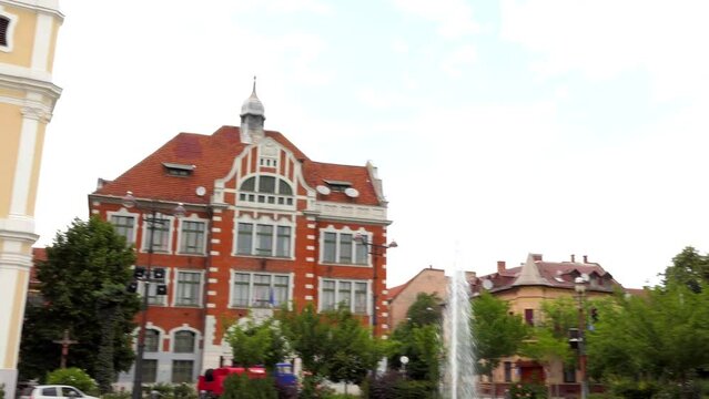 MISKOLC, HUNGARY - JULY 10 2017: Minorite Catholic church, Ferenc Foldes Secondary School and fountain in center of Miskolc, Hungary.